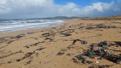 Aspecto de la playa de A Lanzada, en Sanxenxo, llena de basura empujada por las olas a tierra