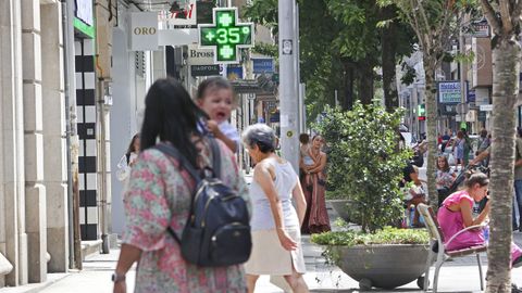 Varias mujeres con nios en brazos por Pontevedra sonde el termmetro marcaba 35 grados ya a medioda