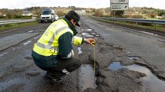 Baches. La foto es de abril del 2018 y explica bien la envergadura que lleg� a alcanzar el deterioro de la N-540. Un guardia civil med�a con una cinta m�trica la profundidad de uno de los baches del tramo que pasa por Chantada, para que un conductor pudiese documentar los da�os que hab�a sufrido su coche