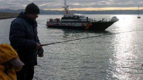 Pescadores recreativos practicando su afici�n en la costa gallega, con una patrullera de la Guardia Civil al fondo, en una imagen de archivo. 