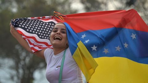 Una mujer ondea las banderas de Estados Unidos y Venezuela durante el concierto celebrado en el puente fronterizo de Tienditas, en C�cuta (Colombia)