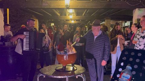 El hostelero Paco Galdo, en primer plano, preparando a sus 90 a�os una queimada durante la �ltima Fiesta de la Sidra celebrada en O Val do Naseiro, este julio