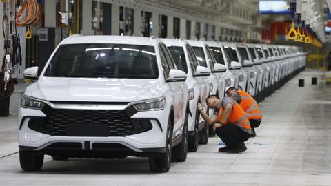 Dos empleados revisan los veh&iacute;culos producidos por la china BYD en la f&aacute;brica inaugurada en Cama&ccedil;ari (Brasil)
