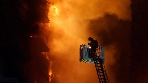 Los bomberos durante las labores de extincin del incendio de un edificio en el barrio Campanar, en Valencia