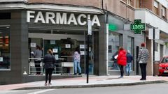 Varias personas esperan para ser atendidas en una farmacia en Pola de Siero