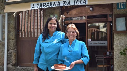 Mar�a y Lola posan con un plato de callos frente al restaurante A Taberna da Lola, en Mourill�s