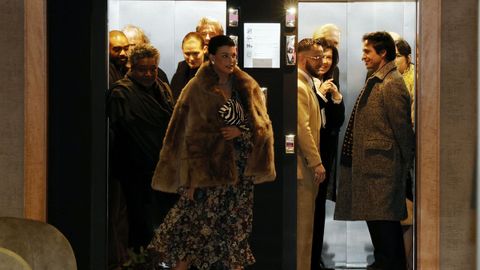 La modelo Linda Evangelista sale de un ascensor del hotel Finisterre mientras el cantante C. Tangana desciende en el otro