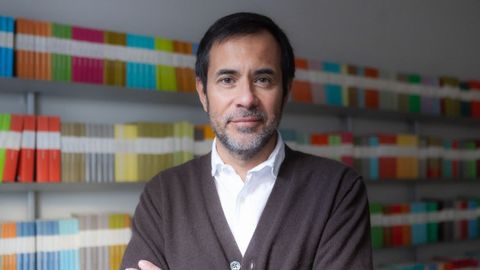 Luis Solano ha cumplido 20 a�os como editor (contra un fondo de sus obras de colores) en Libros del Asteroide.