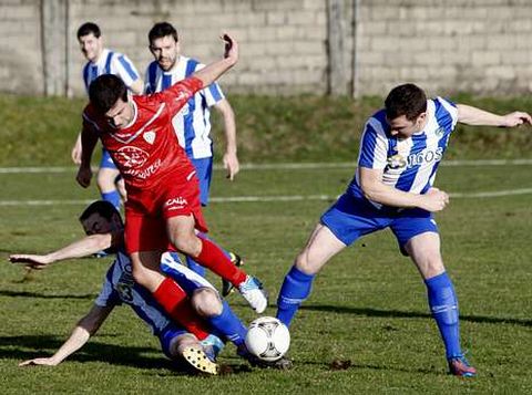 Dos jugadores del Taboada le cierran el paso a un futbolista del Ribadeo.