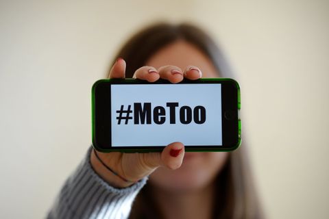 Una mujer sostiene un mvil con el lema MeToo