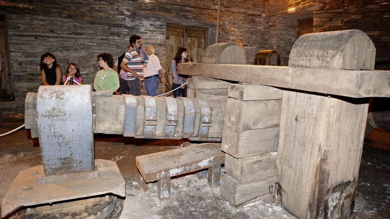 Visitantes ante el mazo de la antigua ferrera de Seoane do Courel, construida en 1810.