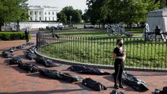 Unas cincuenta bolsas negras que simbolizaban los fallecidos por covid-19 fueron desplegadas frente a la residencia presidencial