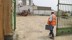 Operario entrando a la parcela donde se levantar� la residencia, que se encuentra explanada y con maquinaria de obra sobre el terreno.