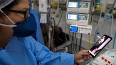 En la imagen de archivo, una enfermera sostiene un m�vil durante una videollamada entre un paciente con covid y sus familiares en Brasil