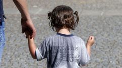 Una ni�a le da la mano a su padre este martes en Monforte despu�s de remojarse la cabeza para aplacar el calor