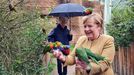 Merkel, alimentando a loros arcoris en un parque de aves en Marlow (Alemania)