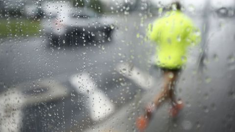 Un corredor haciendo deporte bajo la lluvia 