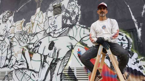 Kapi (@kapi.style), uno de los pioneros del grafiti que participan en Las Meninas, delante de su mural. La obra está protagonizada por un Velázquez pinchadiscos en una discoteca con Meninas bailarinas.