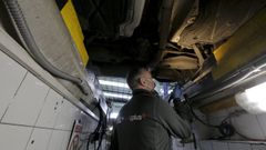 Un inspector examina los bajos de un veh�culo en la estaci�n de ITV de Sada