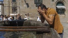 Un transe�nte se refrescan en el casco hist�rico de Santiago de Compostela