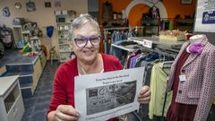 Una voluntaria de Arca de Noia muestra el cartel de la venta de loter�a de Navidad dentro del local donde tienen su tienda solidaria