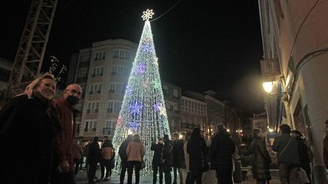Una pareja pasa sonriente frente al �rbol luminoso de 14 metros de la plaza de Espa�a este viernes unos minutos despu�s del encendido del alumbrado navide�o