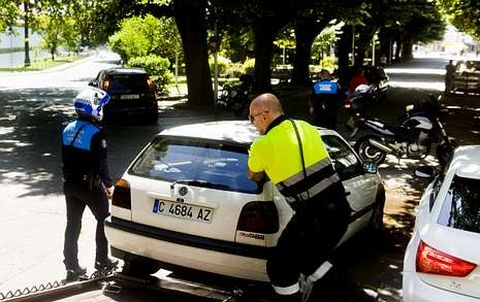Polic�as locales llev�ndose con la gr�a un coche mal estacionado en el Cant�n, en foto de archivo.