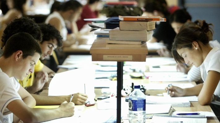 Estudiantes universitarios en una biblioteca.