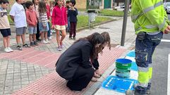 La concejala Tamara Iglesias, pintando las nuevas se�ales junto a alumnos del colegio.