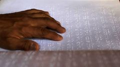 Una persona lee un libro escrito en braille.
