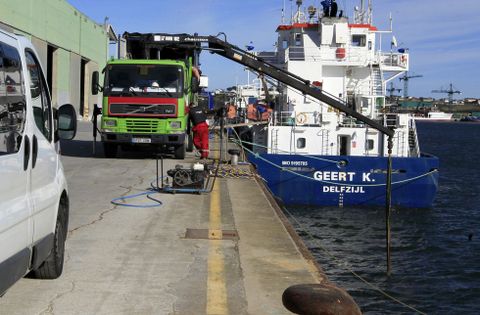 El dragado, desde tierra, de la zona de atraque en el muelle comercial de Mirasol, en Ribadeo. 