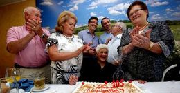 Balbina Blanco, en el centro, con algunos de sus parientes y el alcalde y un edil de Zas, soplando la segunda tarta de la jornada. 