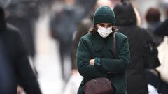 Una mujer, con mascarilla, paseando por una calle de Par�s