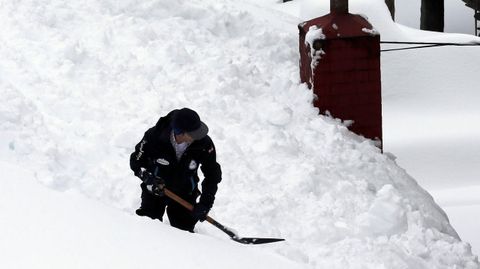 Vecinos de Pajares (Asturias) retiran nieve del tejado de su casa de 300 aos, una de las ms antiguas del pueblo.