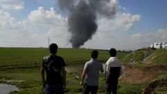 J�venes ven arder un dep�sito de petr�leo en Irak, destruido tras el ataque de un dron a principios de abril.