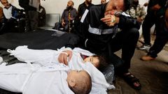 Un gazat llora junto a los cuerpos de sus hijos en Rafah.