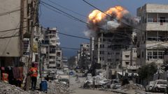 Fuego y humo sobre un edificio bombardeado por Israel en la Ciudad de Gaza