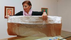 Silvia Longueira envolviendo uno de los cuadros reclamados