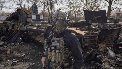 Un militar ucraniano, junto a los restos de un tanque ruso en las afueras de Kiev