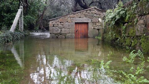 El ro Umia baja desbordado a la altura del puente de Bain, en Vilanova de Arousa