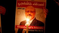 Un manifestante sostiene una vela enfrente del retrato de Khashoggi tras su asesinato en Estambul.