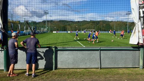 Dos de los jardineros del Deportivo observan un entrenamiento del equipo en Abegondo