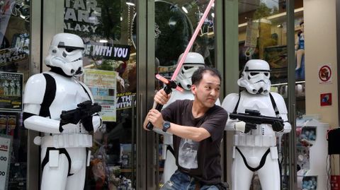 Un fan japons posa ante una tienda de juguetes en Tokio.