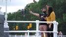 Una pareja de turistas se hace un autorretrato en el paseo de la playa de San Lorenzo en Gijón