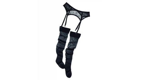 Anna Sui x Zara. Look Vintage Completo Conjunto de cuatro piezas recreado a partir de la pasarela Otoño 1995 de Anna Sui. Incluye un vestido negro de manga larga con falda de tablas, cuello y puños blancos, cinturón tipo cadena con dijes, medias transparentes y una liga en una sola pierna. El conjunto mezcla una silueta de uniforme escolar con el estilo subversivo característico de Sui. Se vende en caja como look completo