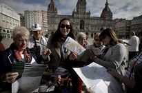 Un grupo de cruceristas examina sus mapas de la ciudad en la plaza de Mar�a Pita. 