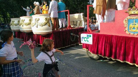 Una ni�a lanza confeti a una carroza del desfile del D�a de Am�rica en Asturias.Una ni�a lanza confeti a una carroza del desfile del D�a de Am�rica en Asturias