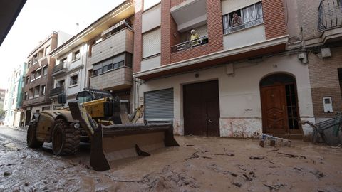 Una mquina escavadora retira el lodo acumulado en las calles tras las intensas lluvias cadas por la fuerte dana en Catarroja