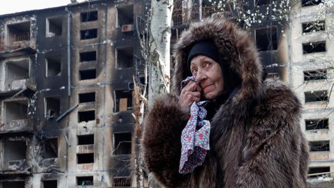 Una mujer llora frente a un edificio bombardeado, este domingo, en Maripol