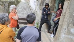 La presidenta de la AVV y otros residentes en el barrio acudieron a hablar con los moradores de la vivienda abandonada este jueves